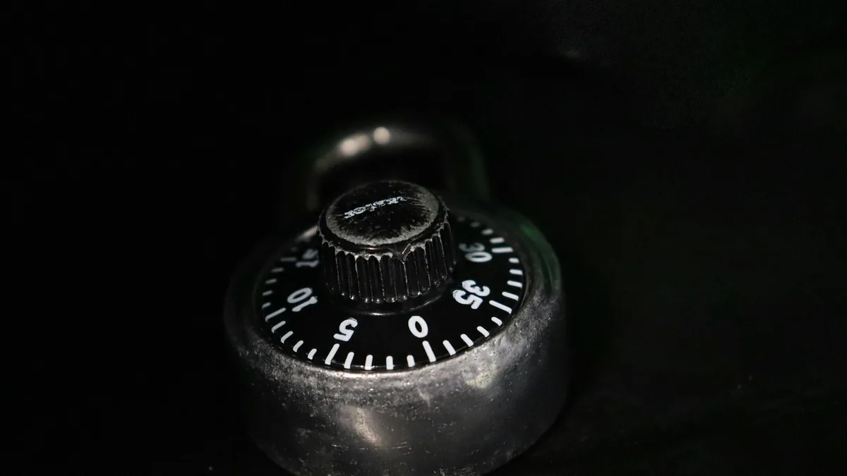 Dial de un candado de combinación sobre una superficie negra
