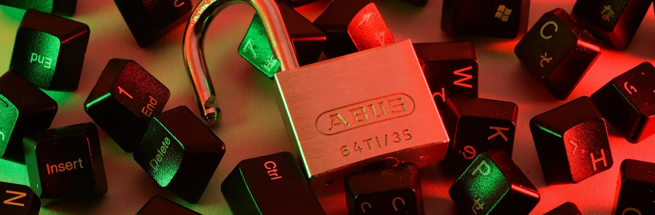 Candado abierto entre teclas de teclado dispersas